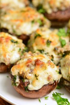 several stuffed mushrooms on a plate with parsley