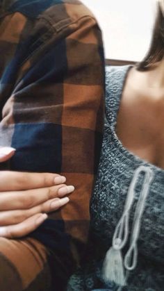 two people sitting next to each other with their hands on the back of one person's shoulder