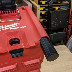 a red tool box sitting on top of a wooden table