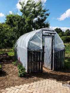 a small greenhouse in the middle of a garden