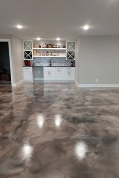 an empty room with white cabinets and gray flooring is pictured in this image, there are no people or objects on the shelves