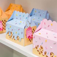 small ice cream boxes with colorful sprinkles on them and tags hanging from them