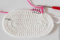 the crochet hook is being used to make an oval dishcloth