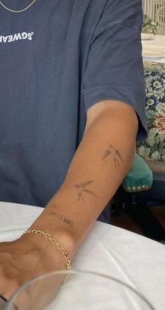 a man with a tattoo on his arm sitting at a table