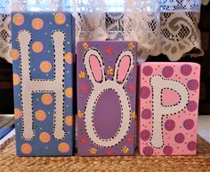 two wooden blocks decorated with bunny ears and the word hop painted on them