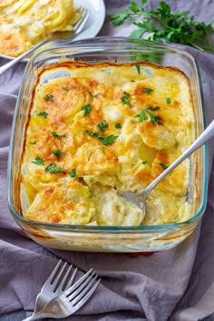 a casserole dish with potatoes and parsley in it on a purple cloth