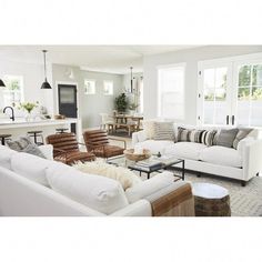 a living room filled with white furniture and lots of windows