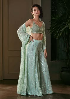 Editor's Note The lurex georgette bra top with wide-leg pants and cape is a chic and glamorous ensemble. The bra top, made from lurex georgette fabric, adds a touch of sparkle and shimmer to th... Cape Set, Indian Dresses Traditional, Indian Bridal Outfits, Pretty Prom Dresses, Couture Designers, Sharara Set, Indian Wedding Outfits, Indian Designer Outfits