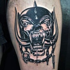 a man's leg with a skull and helmet tattoo on it