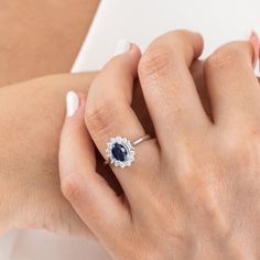 a woman's hand with a diamond and sapphire ring