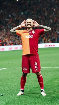 a man standing on top of a soccer field holding his hands behind his head and covering his eyes