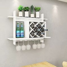 a wall mounted wine rack with bottles and glasses hanging from it's sides on the wall