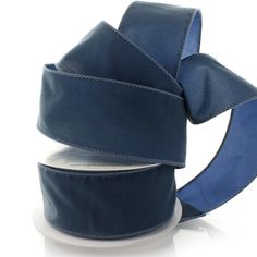 a roll of blue satin ribbon on a white background