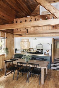 an open kitchen and dining room area with wood paneling