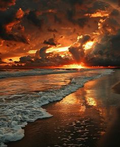 the sun is setting over the ocean with clouds in the sky and waves on the beach