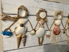 several seashells are hanging on a wall with rope and burlocks attached to them