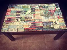 a coffee table covered in newspaper paper on top of a tile floor next to a wall