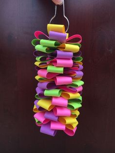 a hand holding a bunch of colorful paper on top of a wooden door with clips attached to it