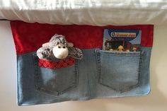 a stuffed animal is sticking out of the pocket of a pair of jeans that are hanging on a wall