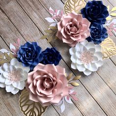 three paper flowers sitting on top of a wooden table