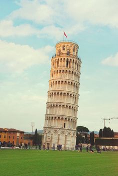 the leaning tower of pisa in italy with people walking around