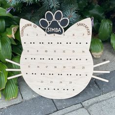 a wooden calendar with a cat's paw on it and the words simba written in black