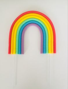 a rainbow shaped lollipop stick on a white background with the colors of the rainbow