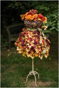 a mannequin made out of flowers and leaves in the shape of a dress