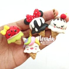 a hand holding five miniature ice creams in different shapes and sizes, all decorated to look like cartoon characters