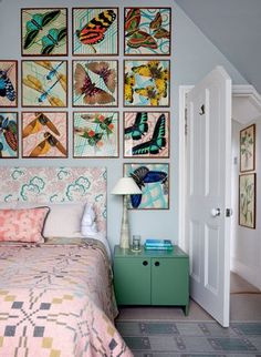 a bedroom with pictures on the wall above the bed and dresser in front of it