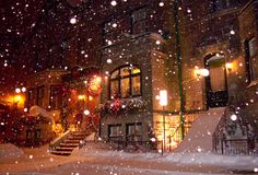 snow is falling on the ground in front of a building and steps leading up to it