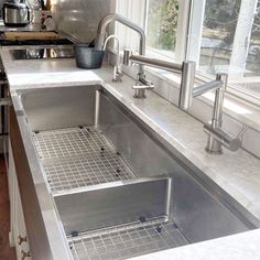 a stainless steel kitchen sink in front of a window