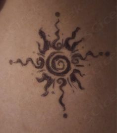 a tattoo design on the back of a woman's lower back neck and shoulder