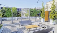 an outdoor deck with chairs, tables and potted plants on the roof top terrace