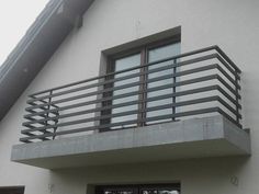 a white building with a metal balcony and door