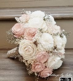 a bridal bouquet with pink and white flowers on the side of a wooden staircase