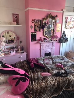 a bedroom decorated in pink and black with leopard print on the bedspread, mirror, dresser and chest