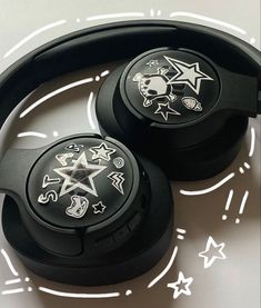 two black headphones with skulls and stars on them sitting on top of a table