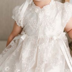 Handmade in the USA This girls Baptism gown is so gorgeous and so detailed, it's not a stretch to say that it is truly a work of art. The lace overlay on this baptism gown is both stunning and special, made of embroidered netting with a rich floral design featuring embroidered flowers in a pretty shade of ivory with champagne cording, adding depth and richness. Trimmed in ivory Venice edging and long ivory silk ribbon bows flowing down the skirt. Includes the matching sheer lace bonnet. This bea Christening Outfits, Baptism Gown Girl, Lace Bonnet, Lace Coat, Baptism Gown, Baptism Outfit, Christening Gown, Christening Outfit