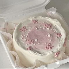 a cake in a white box with pink frosting