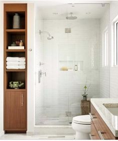 a bathroom with white tile and wooden cabinets