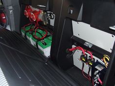 two batteries in the back of a car with wires and other electrical equipment on it