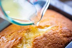 a person pouring milk into a cake