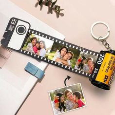 a camera keychain with two photos attached to it and a couple's name tag