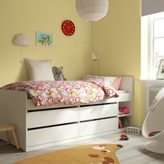 a child's bedroom with yellow walls and white furniture