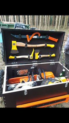 an open tool box filled with tools on the side of a road next to a man