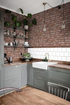 a kitchen with brick walls and wooden floors