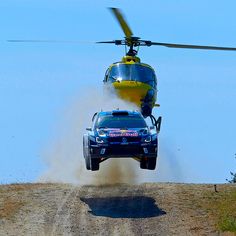 a truck is jumping off the ground in front of a helicopter