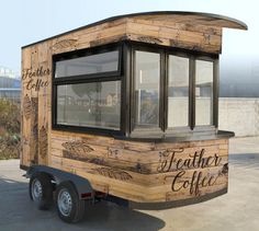 a wooden trailer with the words leather coffee painted on it's side and windows