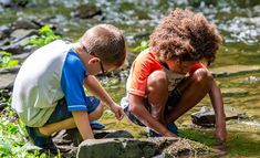 two young boys are playing in the water